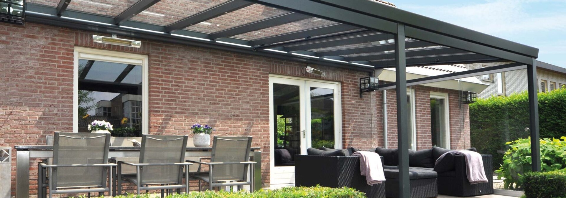 Verasol Profiline veranda met glazen dak en ruime zithoek in de tuin
