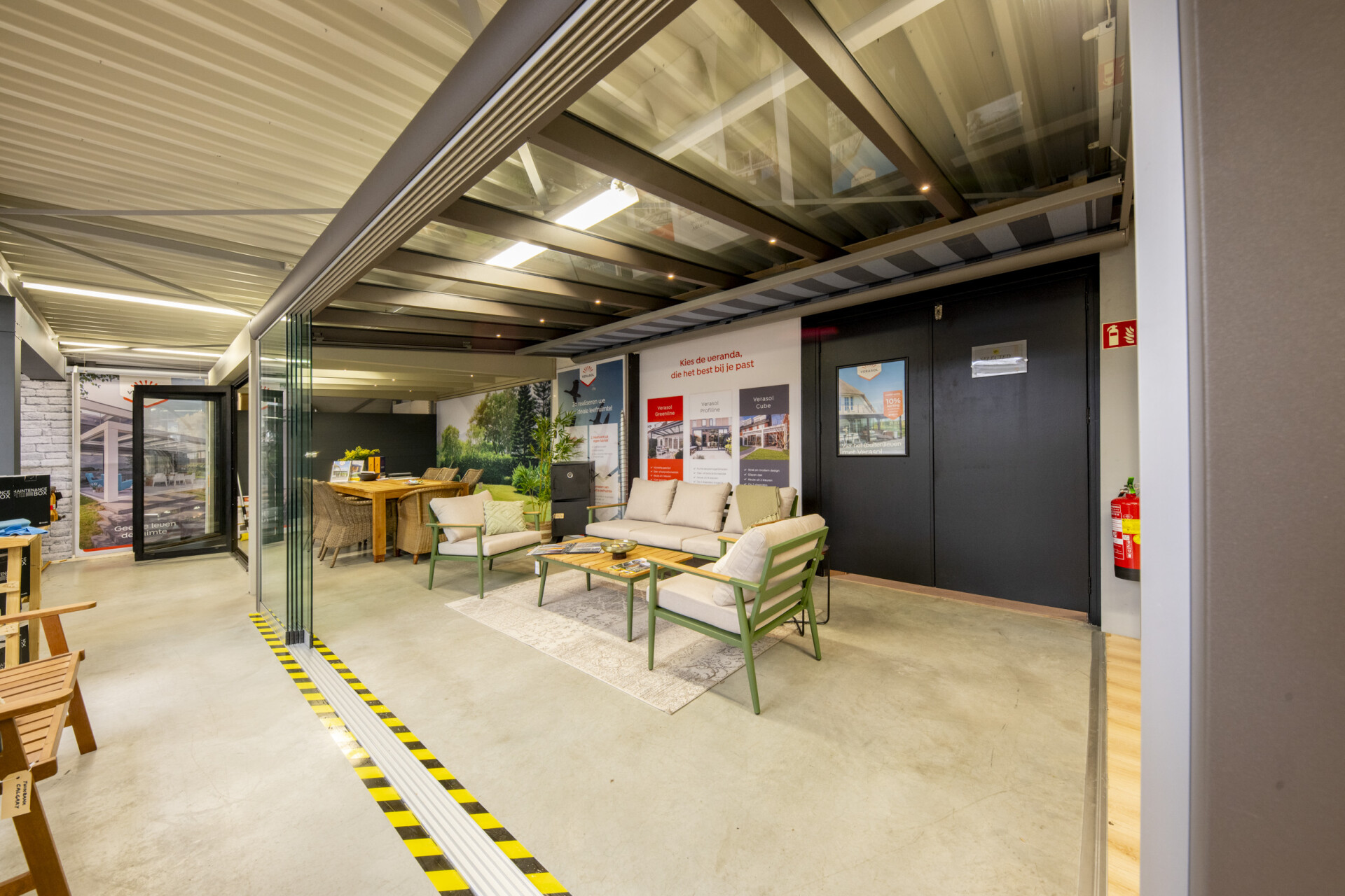 Showroom van Veranda Broers in Breezand met glazen schuifwand en een sfeervolle zitopstelling onder een modern verandadak.